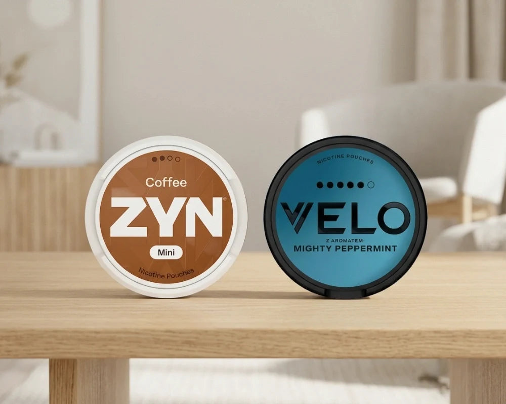 Ένα μικρό κουτί ZYN Coffee και ένα κουτί VELO Mighty Peppermint δίπλα-δίπλα σε ξύλινο τραπέζι