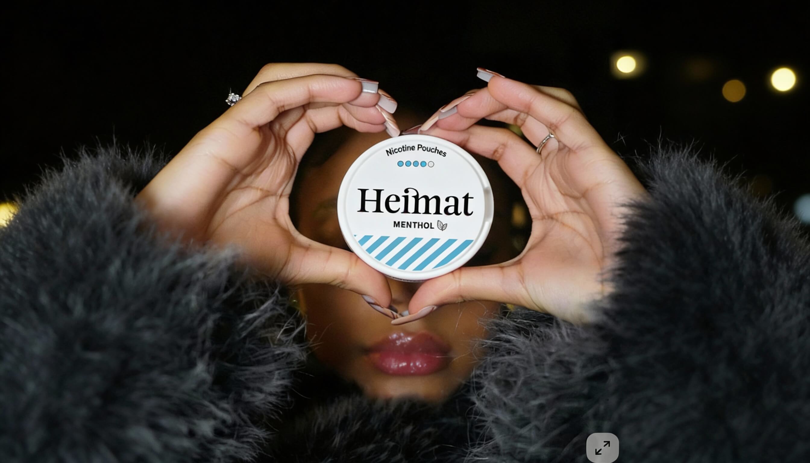 Heimat Menthol Nicotine Pouches Dose in Herzform gehalten, Lifestyle-Aufnahme mit Frau in schwarzem Mantel